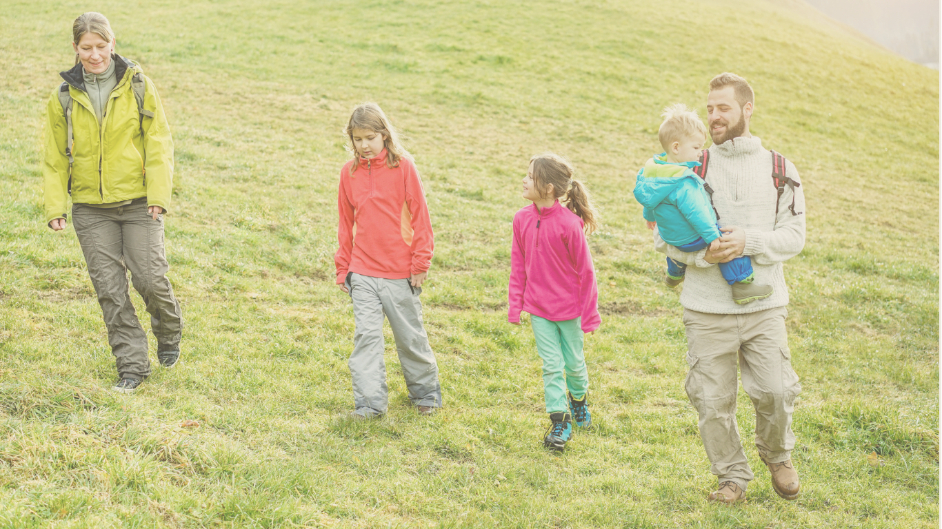 A young family walking toward their RV ready to homeschool and ready for a full-time RV living adventure.
